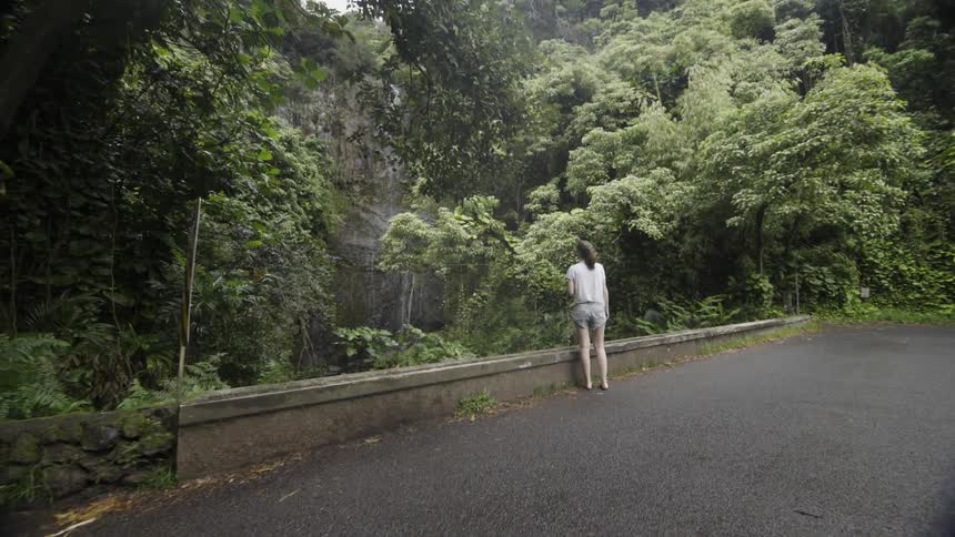 Woman looks out towards trees in the wilderness