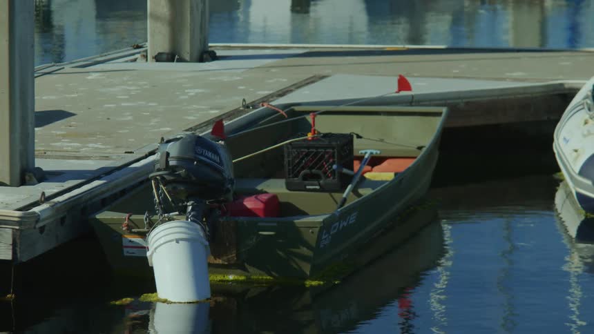 A small boat anchored at a harbor during the day
