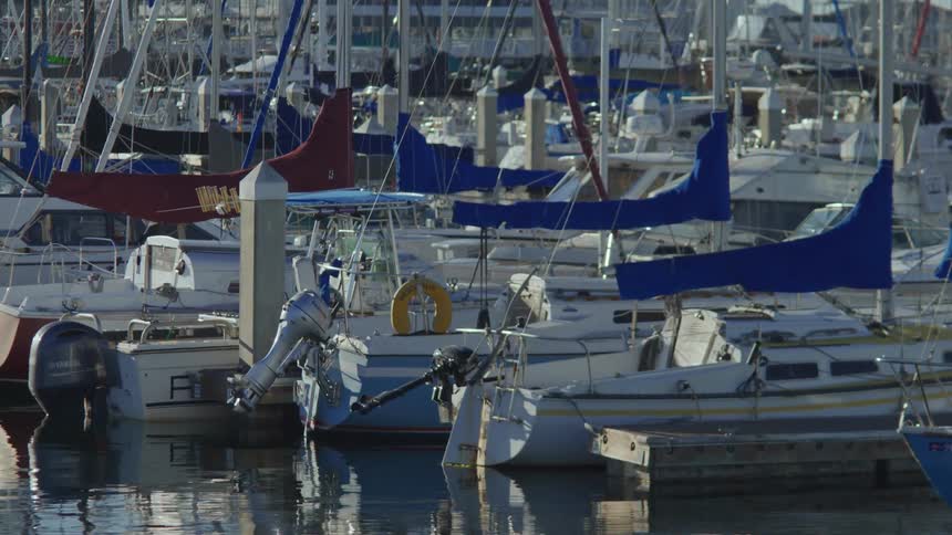 A row of boats docked at a marina at sunset