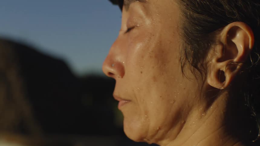 Closeup of a womans face meditating in nature
