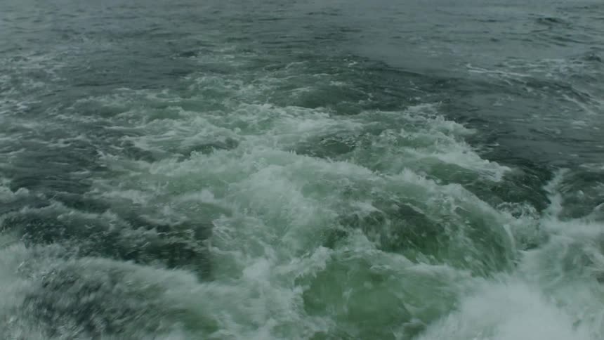 Wake behind a boat in the ocean on a cloudy day