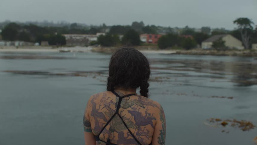 Woman facing the sea on a cloudy day