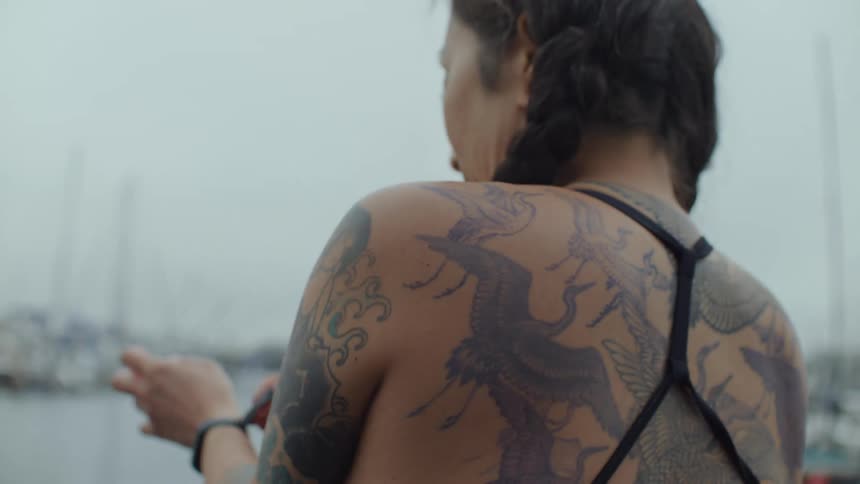 Woman puts on a wetsuit on a boat