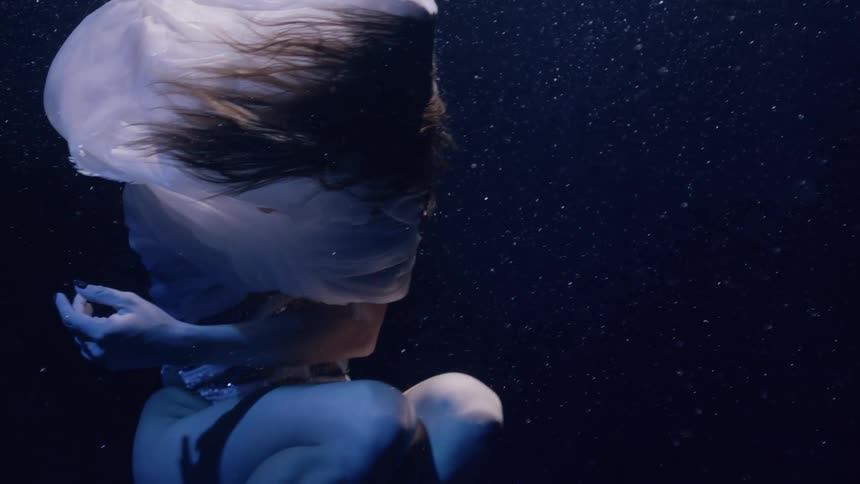 A woman spinning at the bottom of a pool