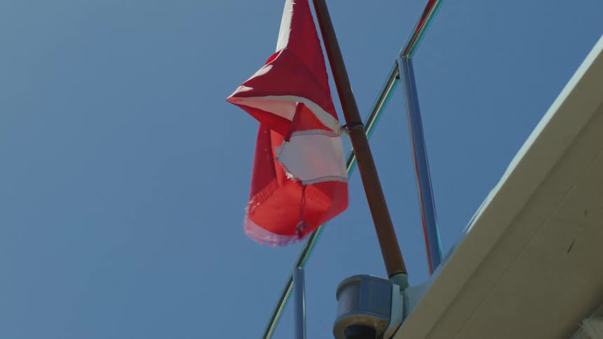View of a dive flag in the wind against a blue sky