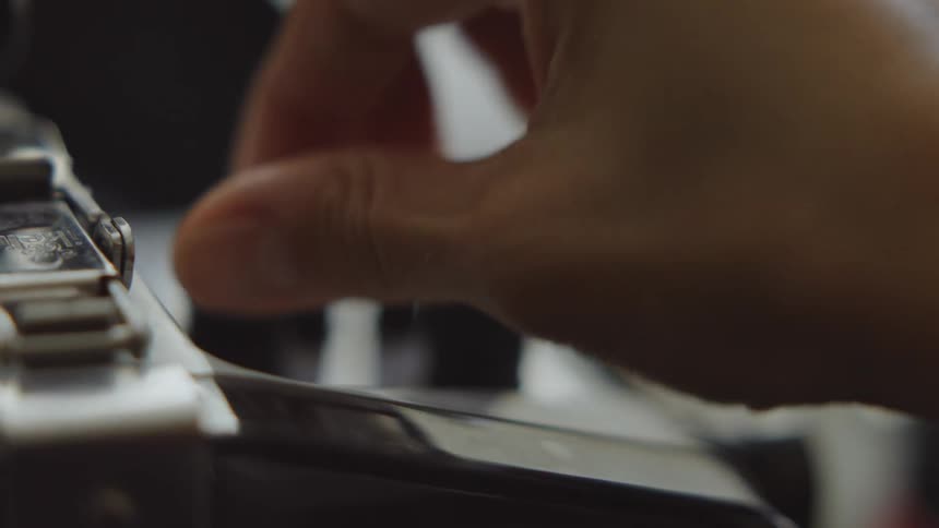 Hands of a person adjusting and turning on an electronic device