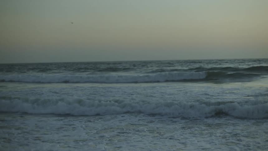 Waves gently crashing at a beach at sunset