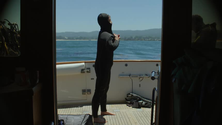 Woman on a boat adjusting her diving suit