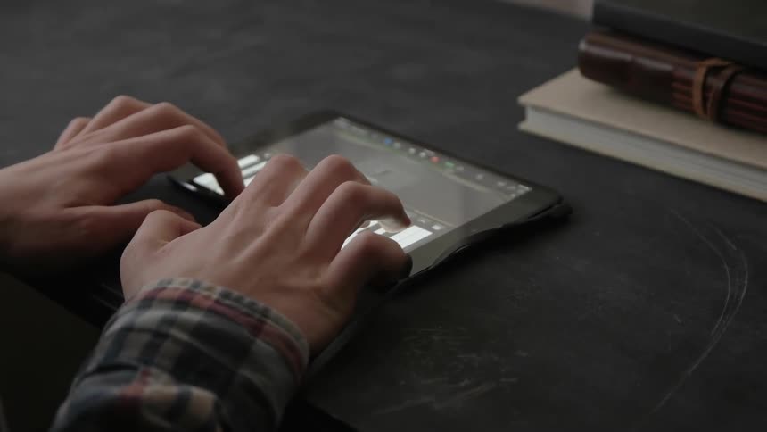 A man is playing a keyboard on his tablet