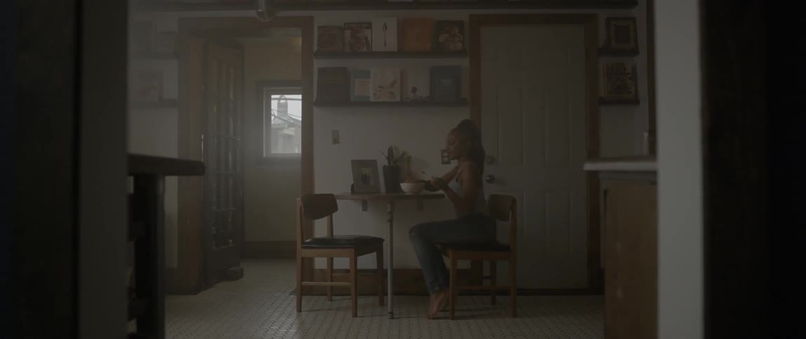 Woman sits down at a table to eat a bowl of food
