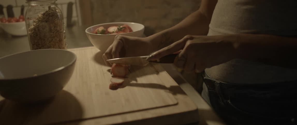 A woman is cutting strawberries