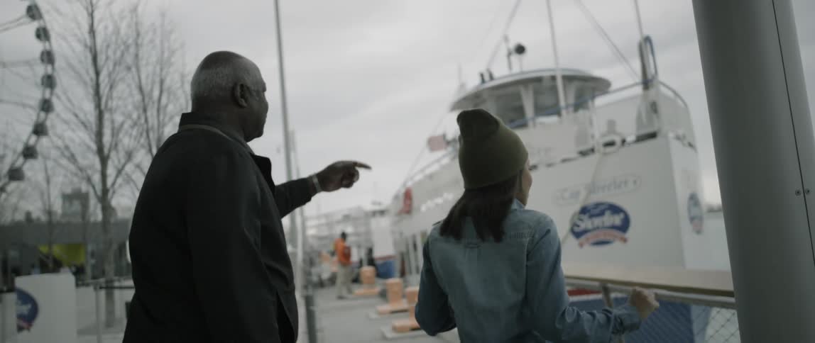 A man and woman walking near a boat