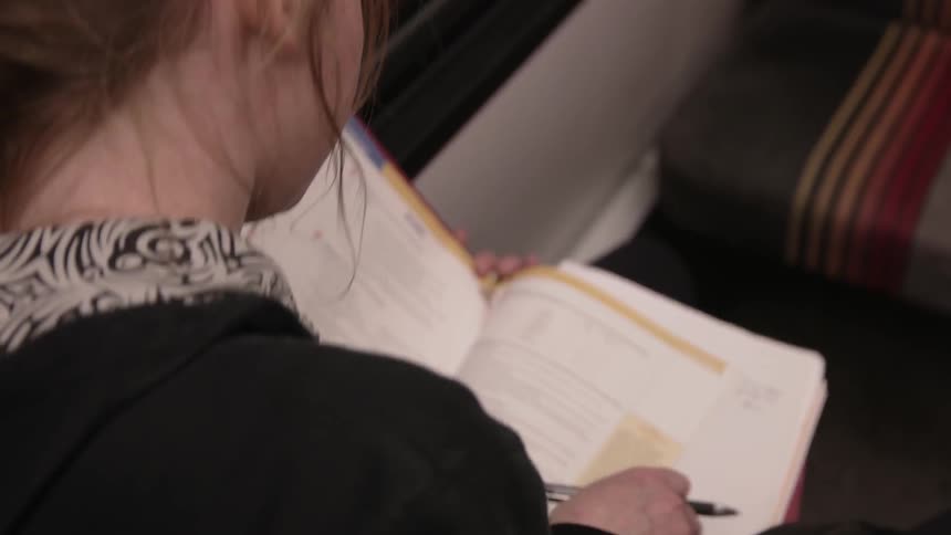 A woman reads a text and takes notes