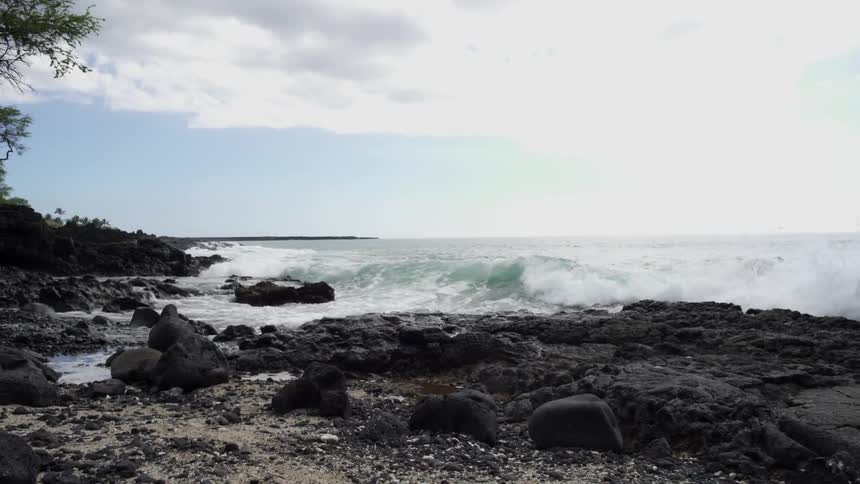 Heavy waves crash on the shore on a cloudy day