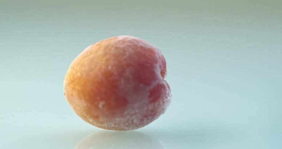 A peach falling on the glass table