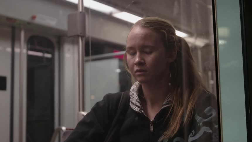 A girl looks out the window of a subway train