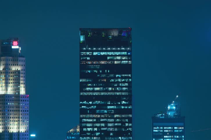View of buildings and skyscrapers at night with lights flashing in timelapse at night