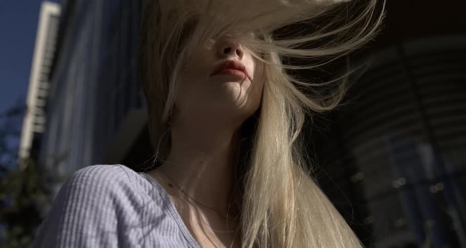 Long hair of a young blonde woman in the city