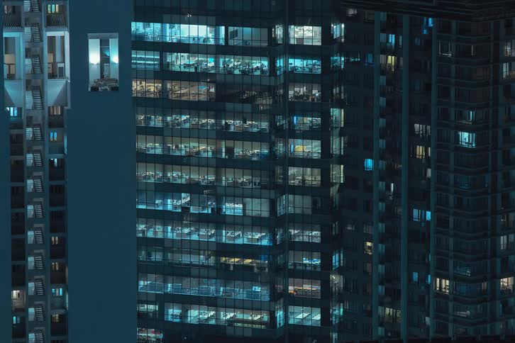 Office building in metropolitan city turning on at night
