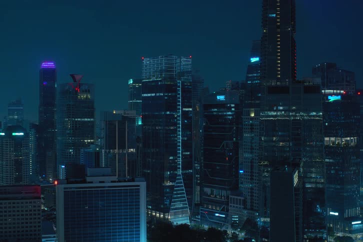 Exterior view of tall buildings and office buildings with flickering window lights that turn off during night
