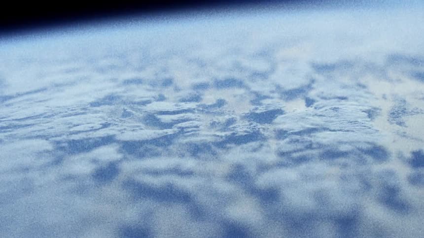 Pale bluish white shapes shift against each other against a black background