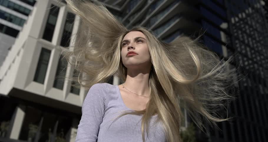 Womans blonde hair flowing in the wind in the city
