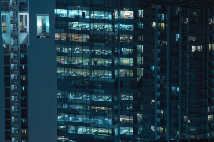 A building with several apartments with the window lights turning on and off
