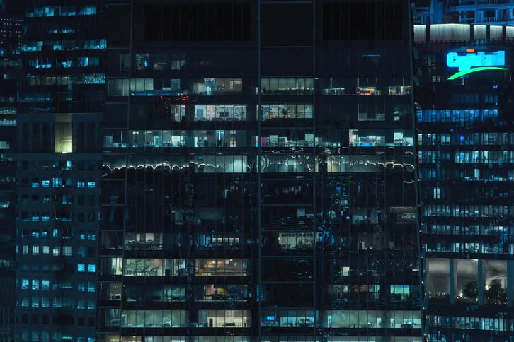 A night clip of skyscrapers in the city and windows flash and pulse