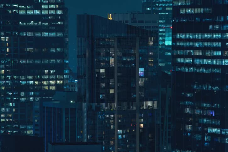 View of an apartment building within a metropolis at night in time lapse with lights blinking furiously