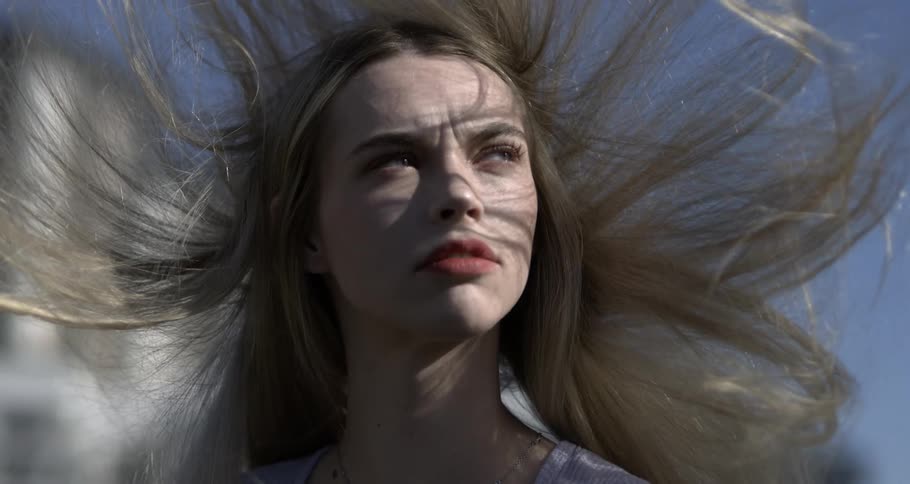 A blond looking angry with the winds blowing her hair