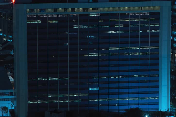 Interior lights in buildings turn on and off as time passes during the night