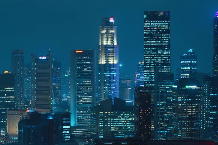 Exterior view of tall buildings and office buildings with flickering lights during night in the city