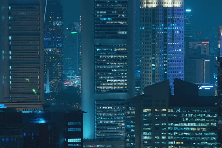 Exterior view of tall buildings and office buildings with flickering lights during night in the city