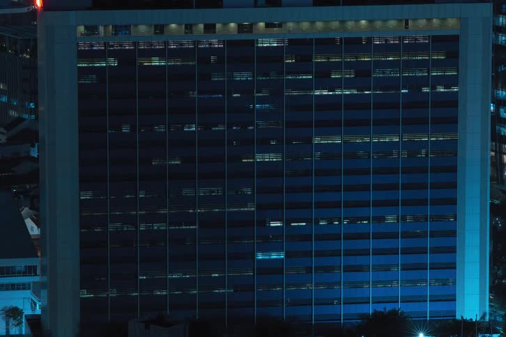 Commercial building at night with lights turning on and off in time lapse