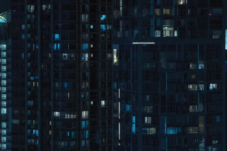 View of a mirrored building with lights turning on and off in time lapse