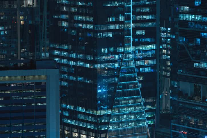 View of skyscrapers in a nighttime metropolis with lights blinking and flashing