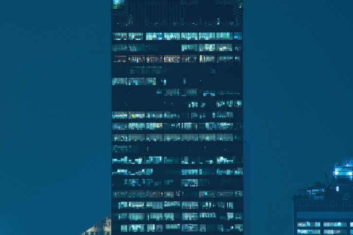 A skyscraper with light illuminating the dark night in the city