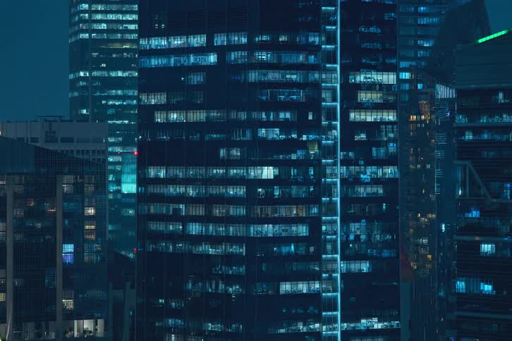 The exterior view captures condos in the city at night with lights flickering painting a vibrant and urban scene