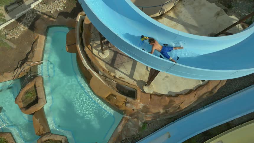 People are going down the blue slide in a water park