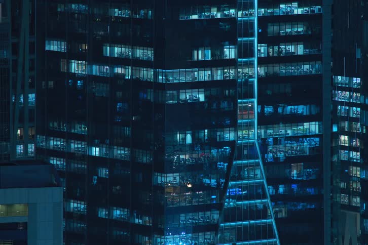 The exterior view captures condos in the city at night with lights flickering painting a vibrant and urban scene
