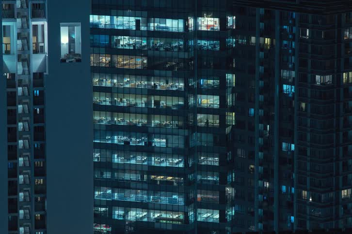 Exterior view of tall buildings and office buildings with flickering lights during night in the city
