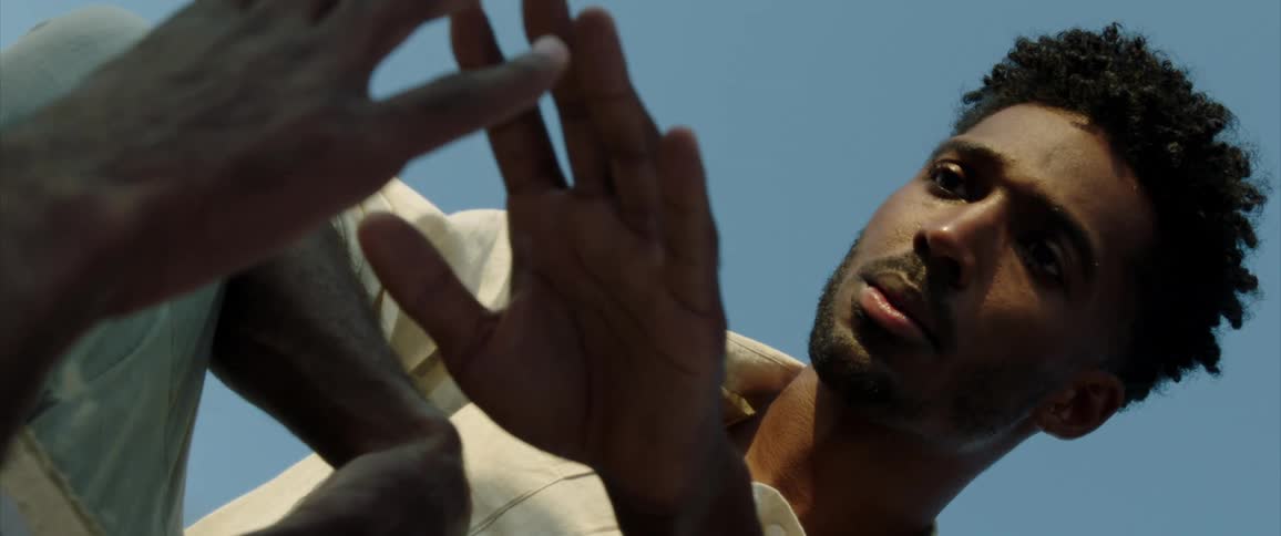A man looking an try to touch his reflection in a mirror