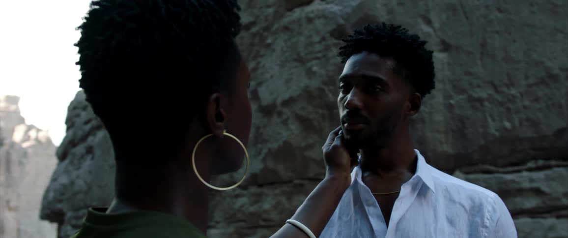 A woman touches a mans face and then slowly removes her hand