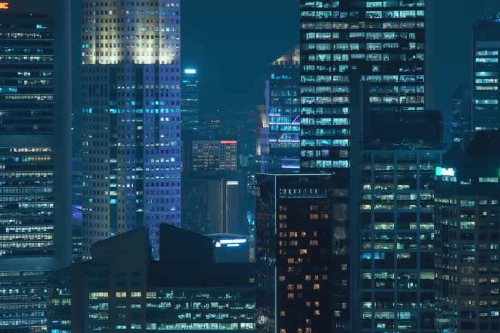 Panoramic view of skyscrapers in a metropolis with lights turning on at night
