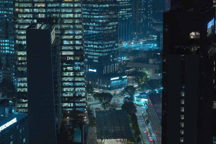 Skyline of a city with illuminated buildings at night turning on