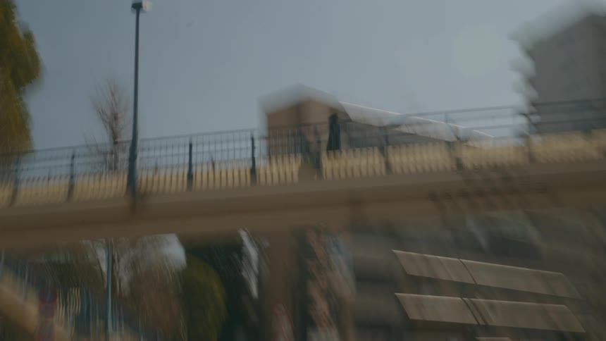 A person walking on a footbridge bridge in the city during the day