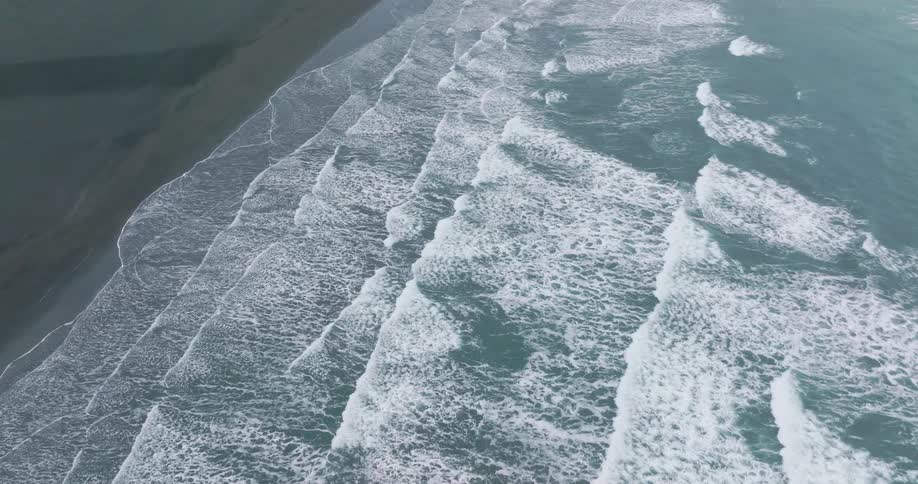 Aerial view of a beach with waves reaching the shore