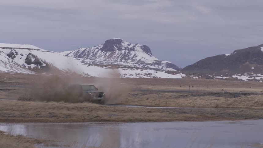 A sports utility vehicle passes through muddy water as it drives offroad