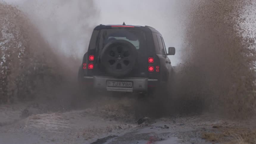 A car passing on a mud road during the day