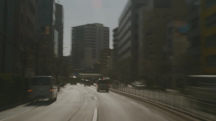 Metropolitan streets with cars and buses driving on the road seen from a car in motion during day ti